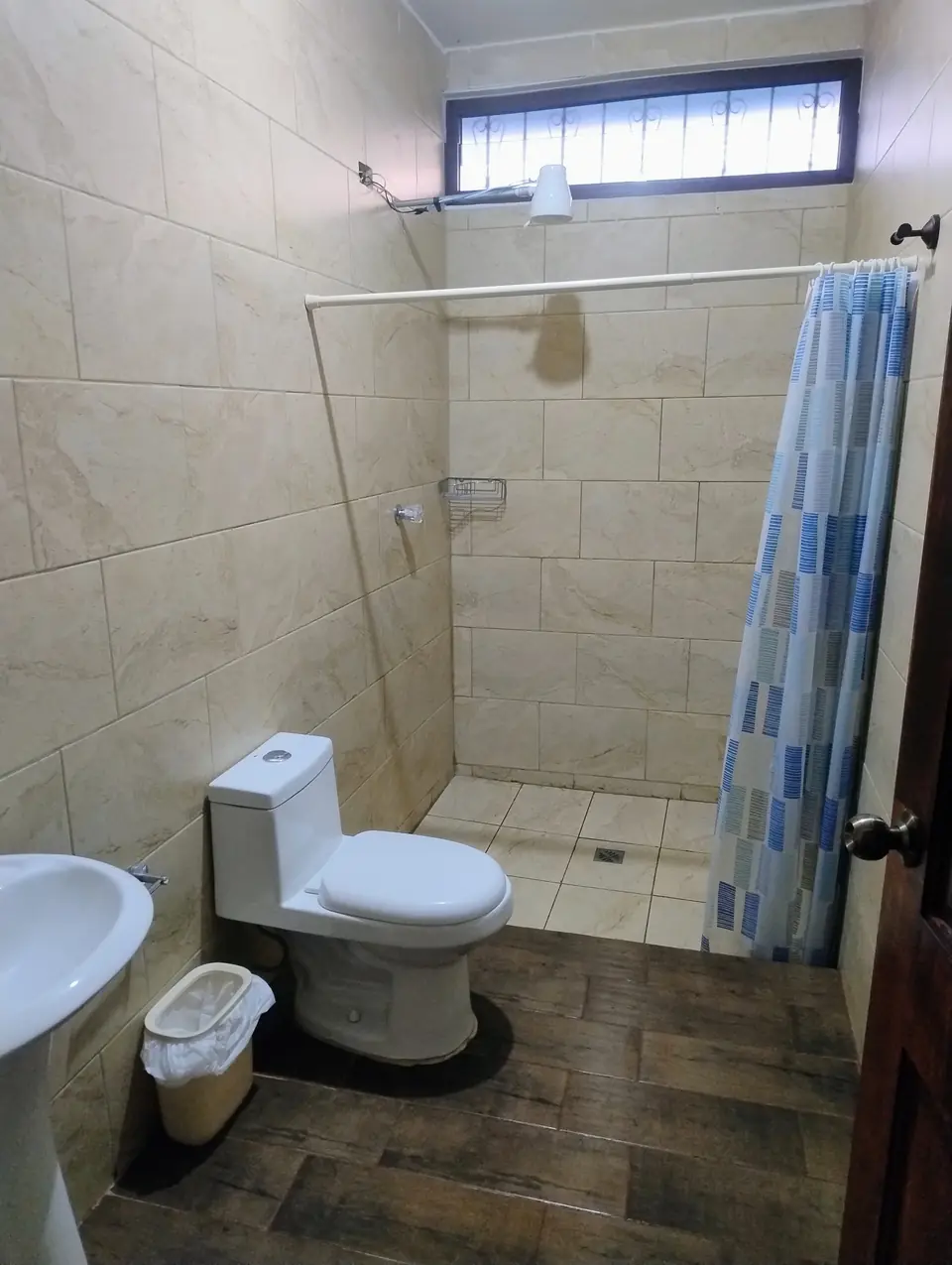 Ducha con cortina azul y sanitario