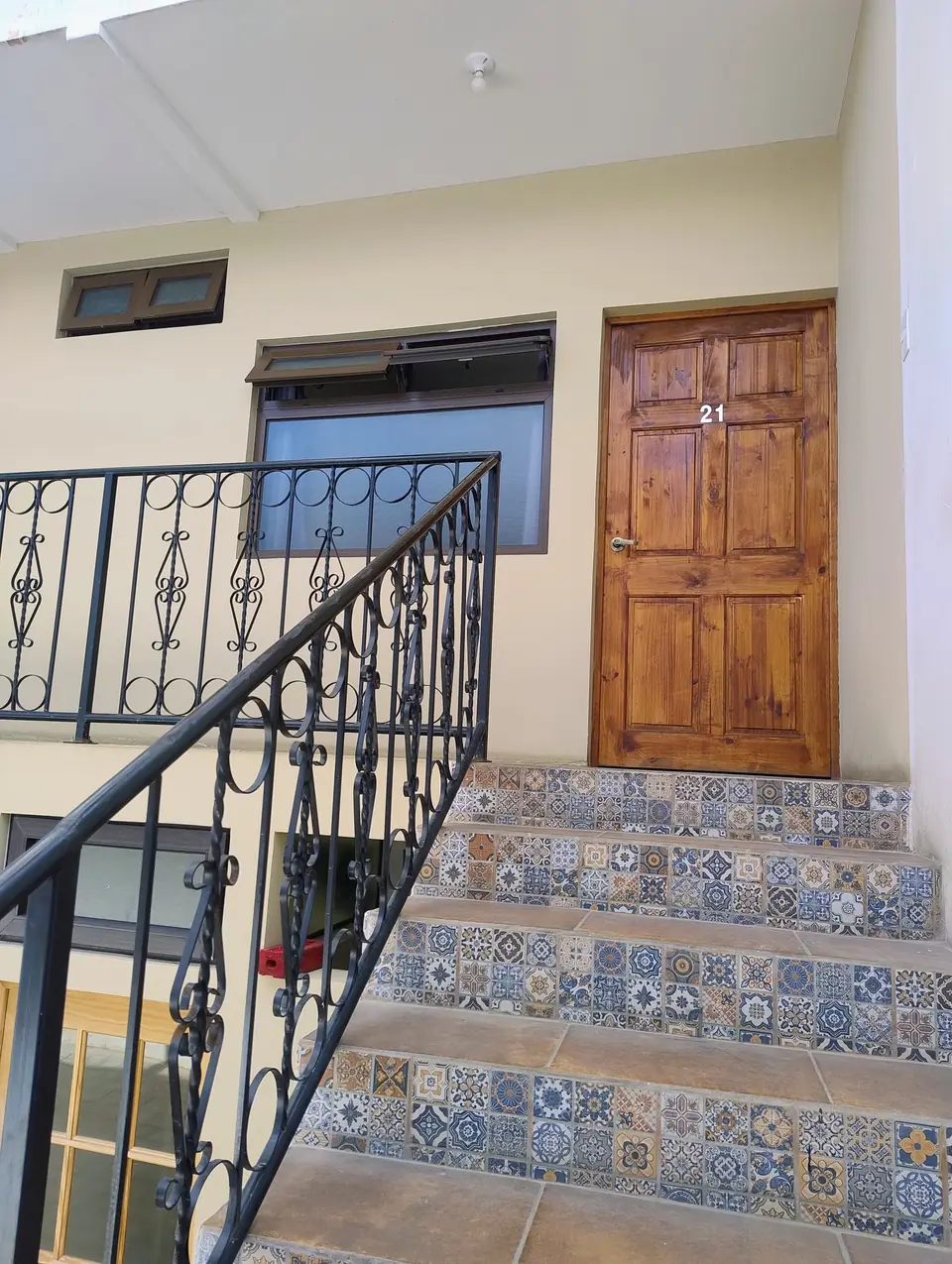 Escalones con azulejos decorados frente a una puerta de madera