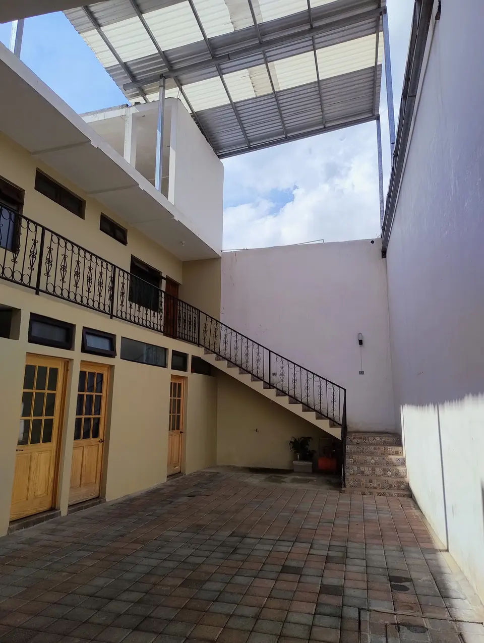 Patio del hotel con escalera y barandas de hierro